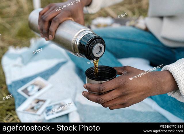 Man pouring tea from insulated drink container