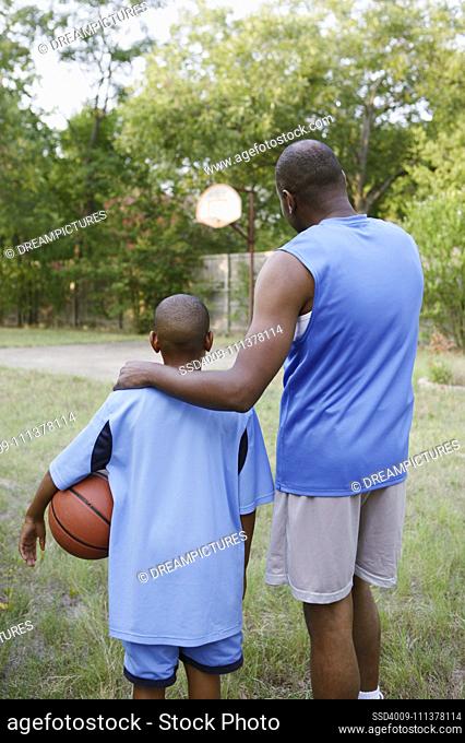Father and son looking at basketball court