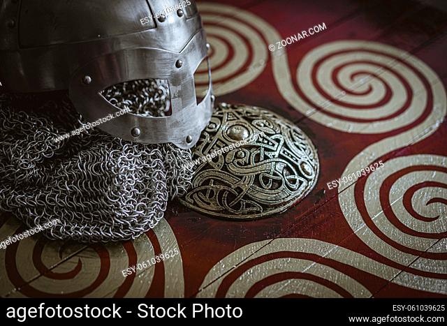 Triskel, Vikings, viking helmet with chain mail on a red shield with golden shapes of sun, weapons for war