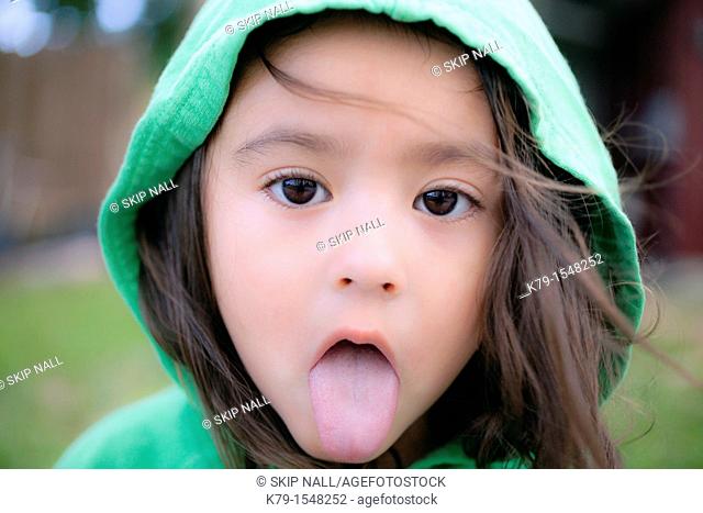 A little girl with her tongue sticking out looking sick