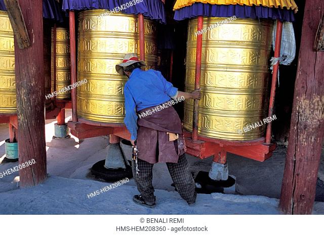 China, Sichuan province, on the outskirts of Daofu, a Khampas man passing trough a series of prayers wheels of a stupa