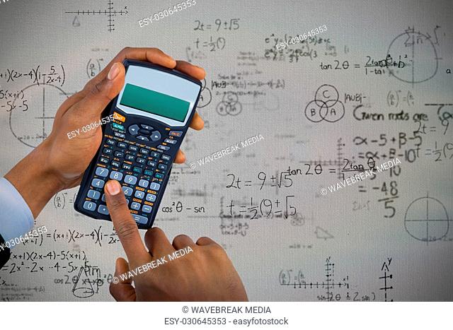Composite image of hands of businessman using calculator