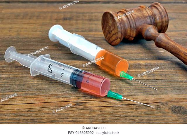 Wooden Judges Gavel And Two Medical Injection Syringe on The Grunge Wooden Table, Top View, Close Up
