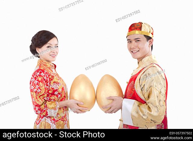 Portrait of young couple in Tang suits holding Jin Dans high quality photo