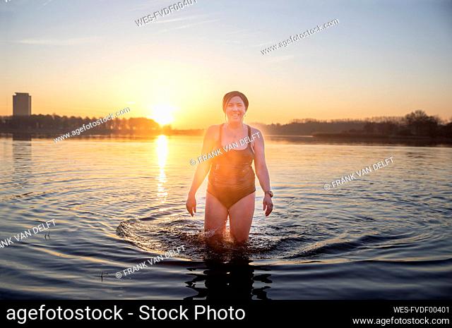 Smiling mature woman standing in water during morning
