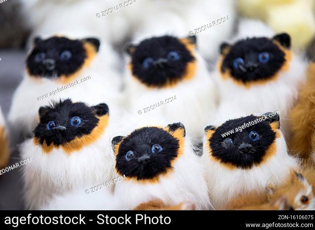 Siamese toy fluffy cats. Many identical kittens