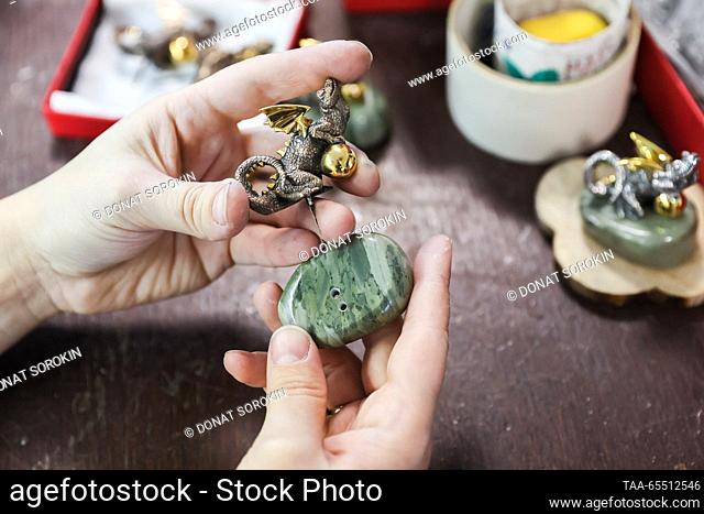 RUSSIA, YEKATERINBURG - DECEMBER 6, 2023: A worker places a bronze dragon on a jasper stone at the Moiseikin jewellery house; the Chinese calendar names 2024...