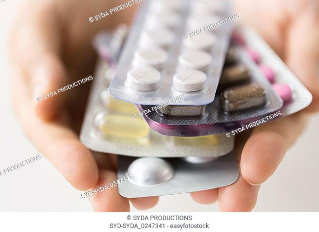 woman hands holding packs of pills