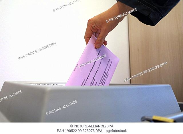 17 May 2019, Mecklenburg-Western Pomerania, Rostock: A voter puts an envelope with his completed ballot paper for the European elections on 26 May 2019 in a box...