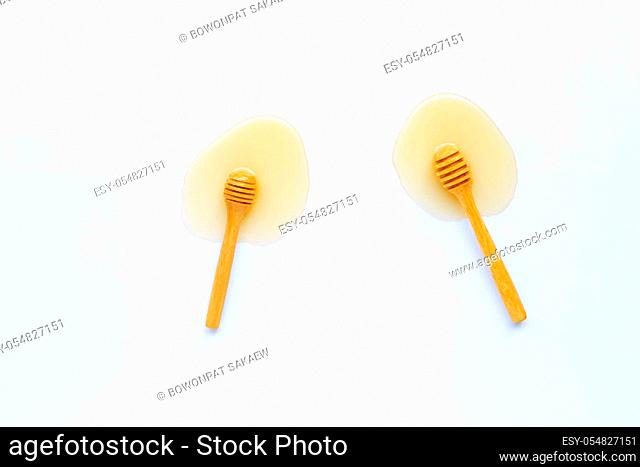 Wooden dipper and honey on white background