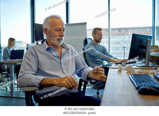 Senior businessman sitting at desk in office