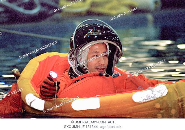 Astronaut Edward T. Lu, Expedition Seven flight engineer, floats in a small life raft during an emergency bailout training session in the Neutral Buoyancy...