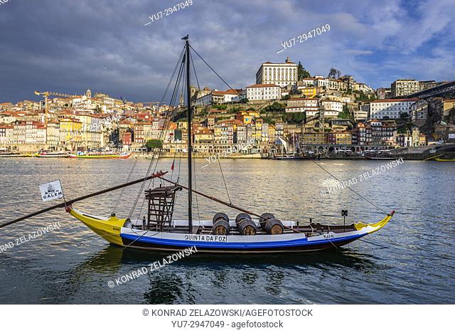 Calem Port wine boat called Rabelo Boat on a Douro River in Vila Nova de Gaia city. Porto city river bank on background