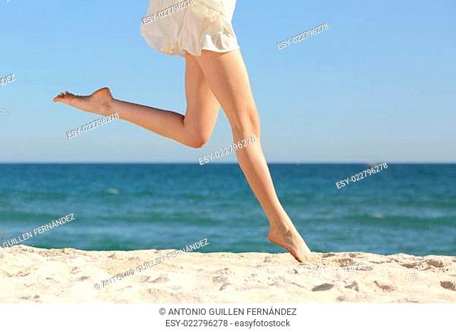 Beautiful woman long legs jumping on the beach