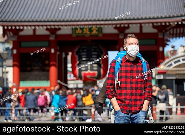 Caucasian tourist wearing a medical mask visiting Tokyo