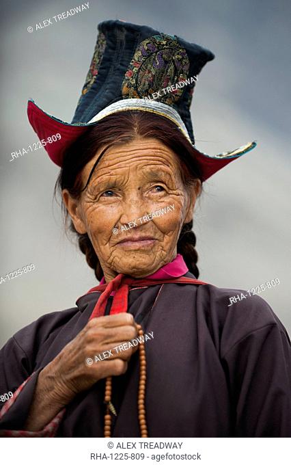 Buddhist woman travelling to a festival at the 14th-century Diskit Monastery, Ladakh, India, Asia