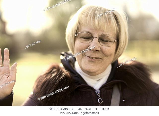 eased senior woman outdoors in park, closed eyes, in Cottbus, Brandenburg, Germany