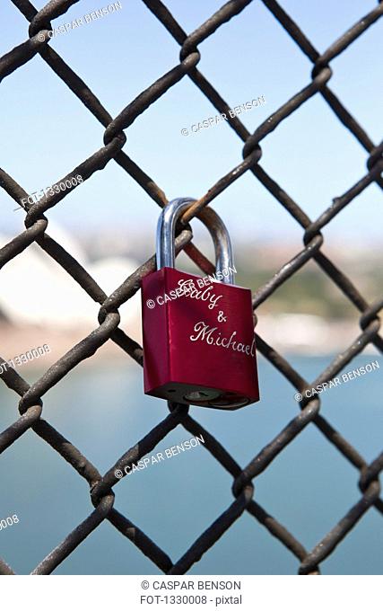 Love padlocks chainlink fence against beach