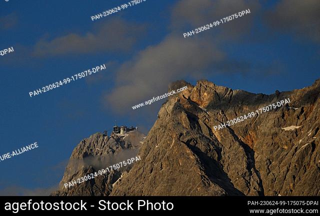 24 June 2023, Austria, Ehrwald: The summit of the Zugspitze seen from the Tyrolean side. Since 2010, the mountain fires of the Tyrolean Zugspitz Arena are part...
