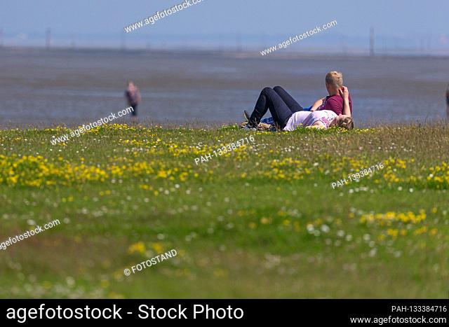 Harlesiel / Carolinensiel, Germany June 2020: Symbolic pictures - 2020 A man and a woman lie on a colorful meadow on the beach of Carolinensiel-Harlesiel and...