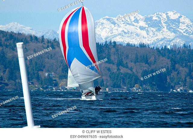 Single boat coming into leeward marke under spinnaker with Olympic Mountains in background