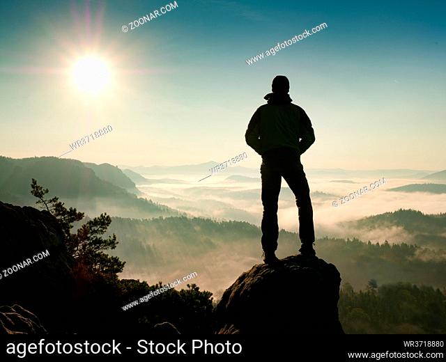 Adventure man looks at the morning horizon in the mountains during an excursion