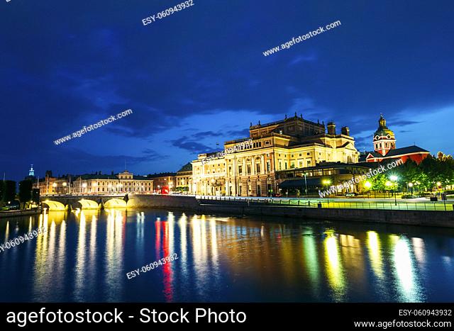Stockholm, Sweden. The Scenic Night View Of Illuminated Royal Swedish Opera Theatre And Norrbro Arch Bridge Over Norrstrom Waterway With Lights Reflections In...