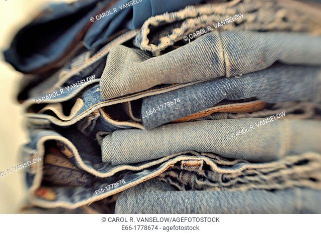 Stack of folded pairs of blue jeans  Shot with LensBaby for selective focus