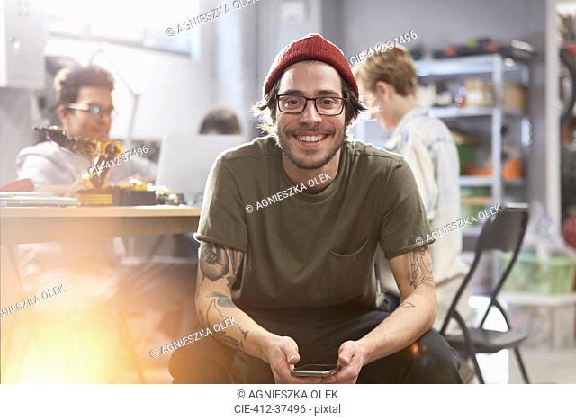 Portrait smiling confident male designer with cell phone