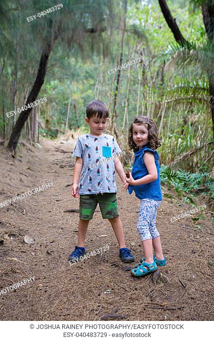 Brother and sister having fun on the Hauula Loop Trail while hiking in Oahu Hawaii