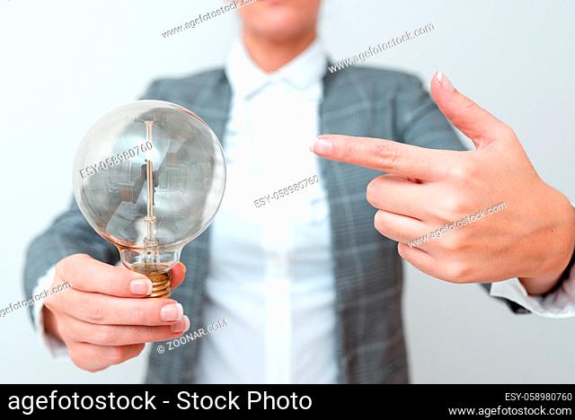 Lady Pointing To Lamp Held In Hand In Formal Outfit Presenting New Ideas For Project, Business Woman Carying Bulb Exhibiting Lately Released Technologies