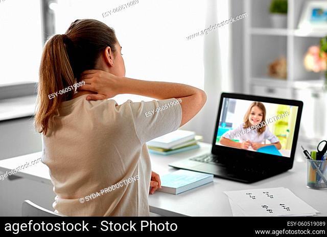 tired teacher with laptop touching neck at home