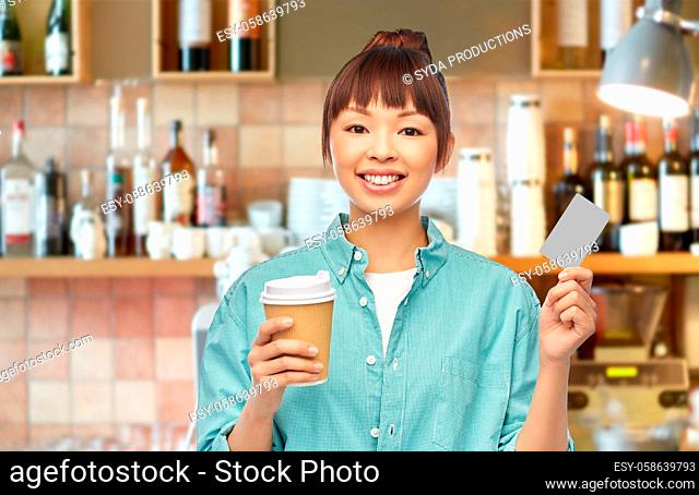 asian woman with coffee and credit card at bar