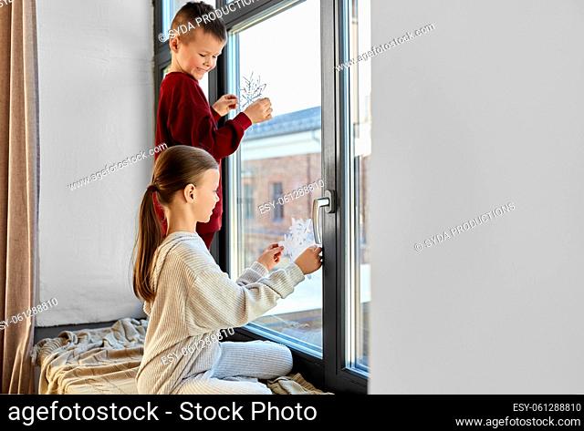 happy children decorating window on christmas