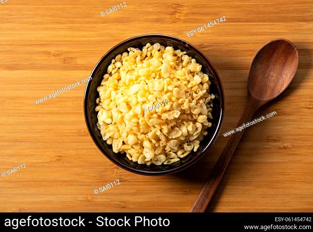 Tenkasu and wooden spoon served in a bowl placed on a wooden background. Image of Japanese food. View from above