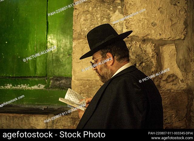 07 August 2022, Israel, Jerusalem: A Jew man prays at the door of the Al-Aqsa Mosque compound in the old city of Jerusalem during the holy day Tisha B'Av