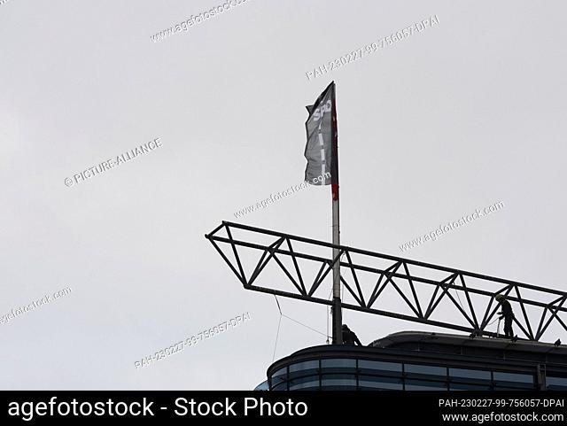 27 February 2023, Berlin: Activists from the environmental group Greenpeace have hoisted a new flag on the roof of the SPD federal party