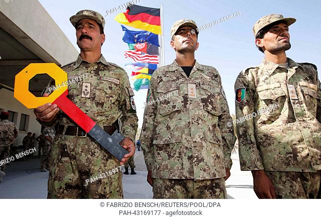 A member of the Afghan National Civil Order Police (ANCOP) holds a symbolic key during the handover ceremony of a German base to Afghan armed forces in Kunduz...