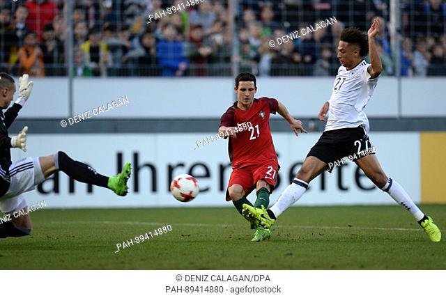 Portugal's Daniel Podence (C) beat's Germany's goalkeeper Odisseas Vlachodimos (L) and Thilo Kehrer with his shot on goal during the men's U21 international...