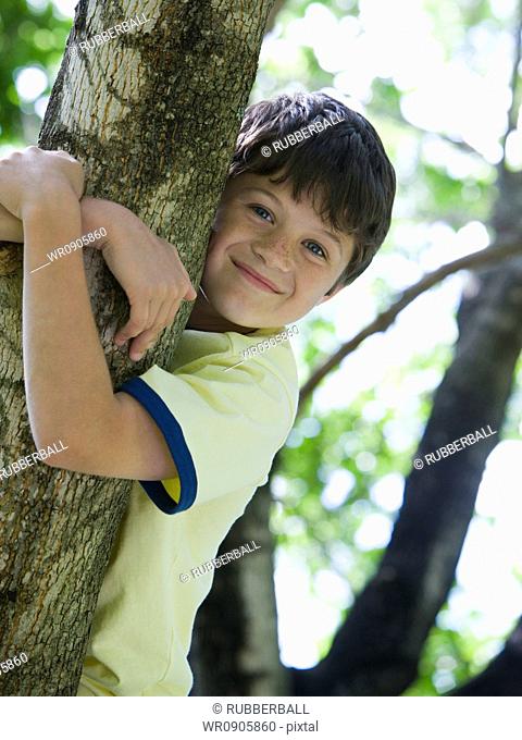 Portrait of a boy holding the branch of a tree