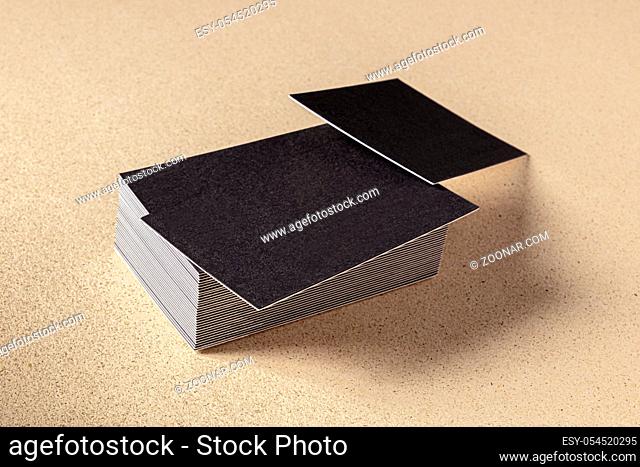Duplex business cards, a mock-up for a stack of dark thick cardboard cards on a brown backgroud