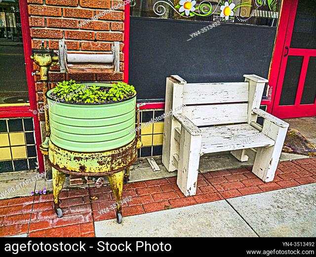Historic downtown Emmett, Idaho sidewalk. Old washtub as a planter. White bench