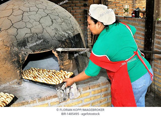 Baker taking finished bread out of the wood-fired oven, San Ignacio, Chiquitania, Santa Cruz Department, Bolivia, South America