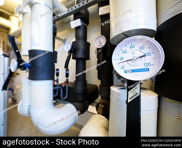PRODUCTION - 26 April 2022, Brandenburg, Teltow: Temperature measurement in the geothermal system in the boiler room of the Albert Schweitzer House
