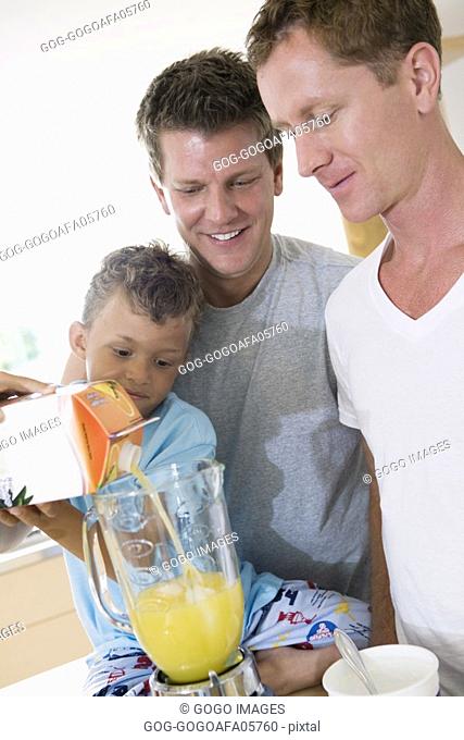Gay couple making smoothies with their son