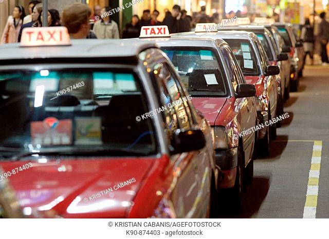 The typical red taxis queueing up idle at a taxi stand in Wanchai (Wan Chai) and waiting for customer, Hong Kong Island, Hong Kong, China, Southeast Asia
