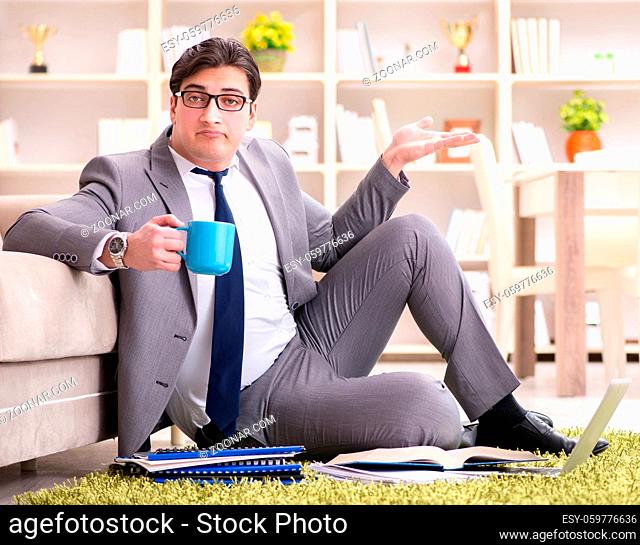 The businessman working on the floor at home