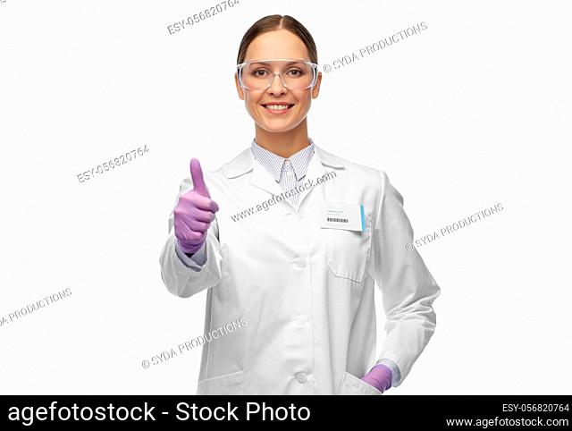 female scientist in goggles showing thumbs up