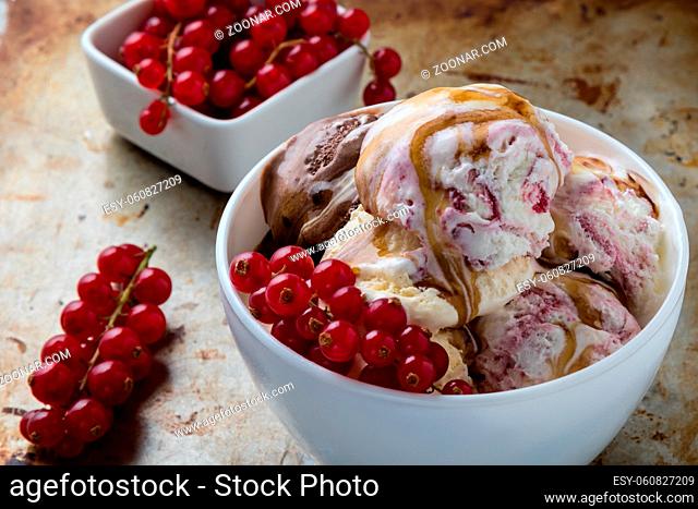homemade ice cream in white bowl with currant on steel plate