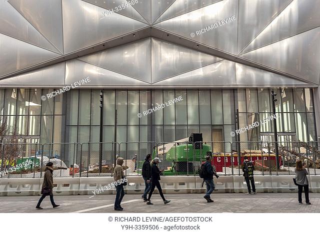 Tourists in the plaza of Hudson Yards pass ""The Shed"" arts space as workers prepare it for its opening, seen on Saturday, March 30, 2019